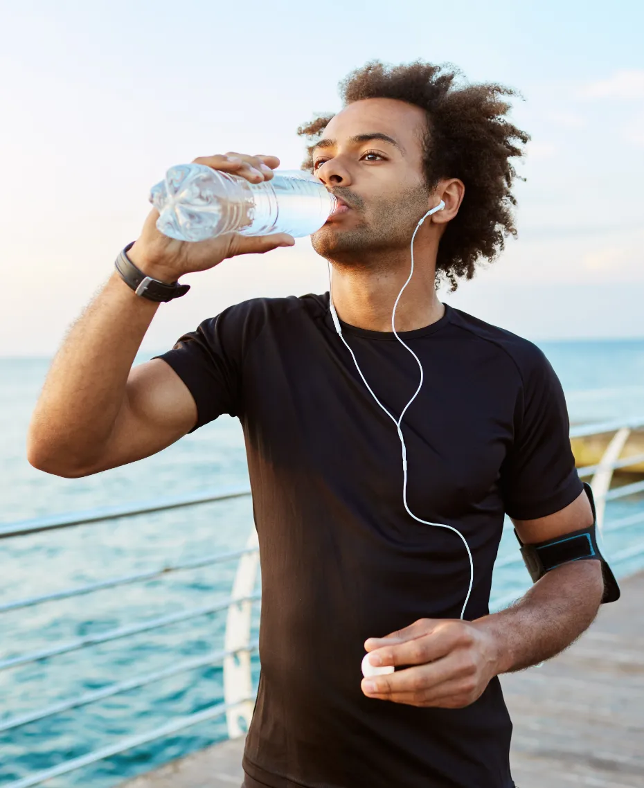 A man drinking water while listening to music.