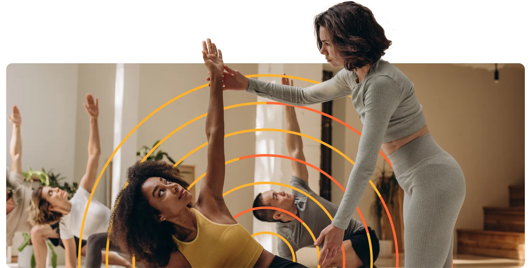 A woman in a yellow tank top is doing a yoga pose.