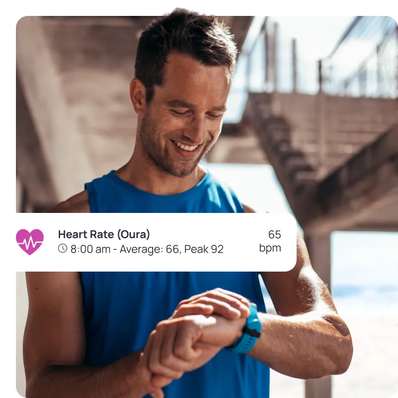A man wearing a blue shirt and blue watch is smiling and looking at his watch with an imported heart rate entry in the Cronometer app.
