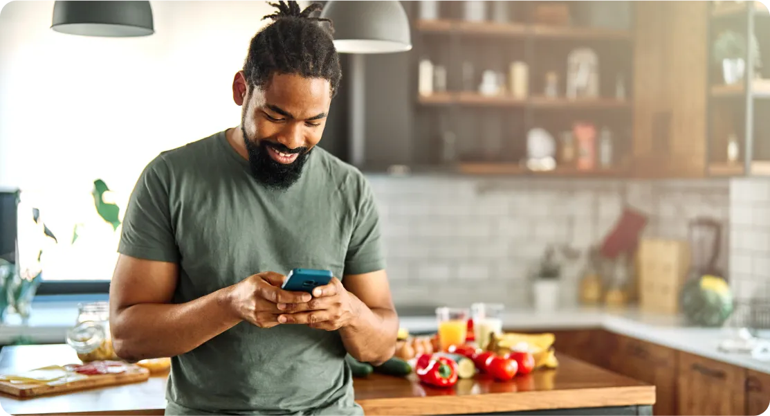 A man with dreadlocks holding a cell phone.
